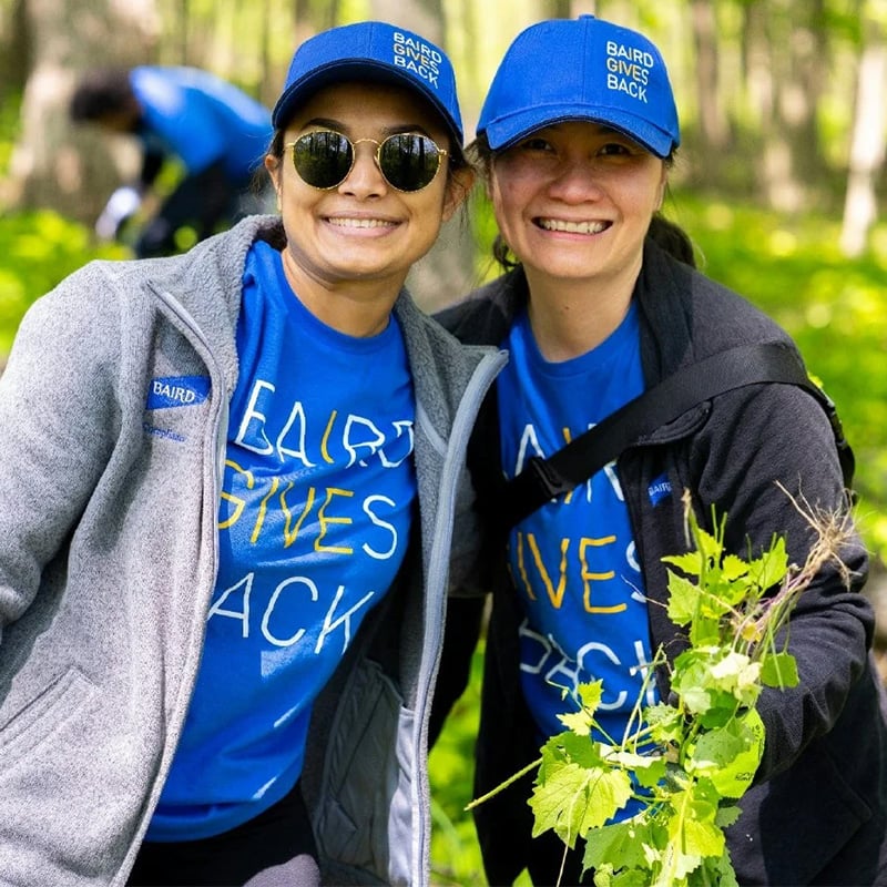 Two Nexus associates volunteering outdoors during in Nexus Gives Back apparel