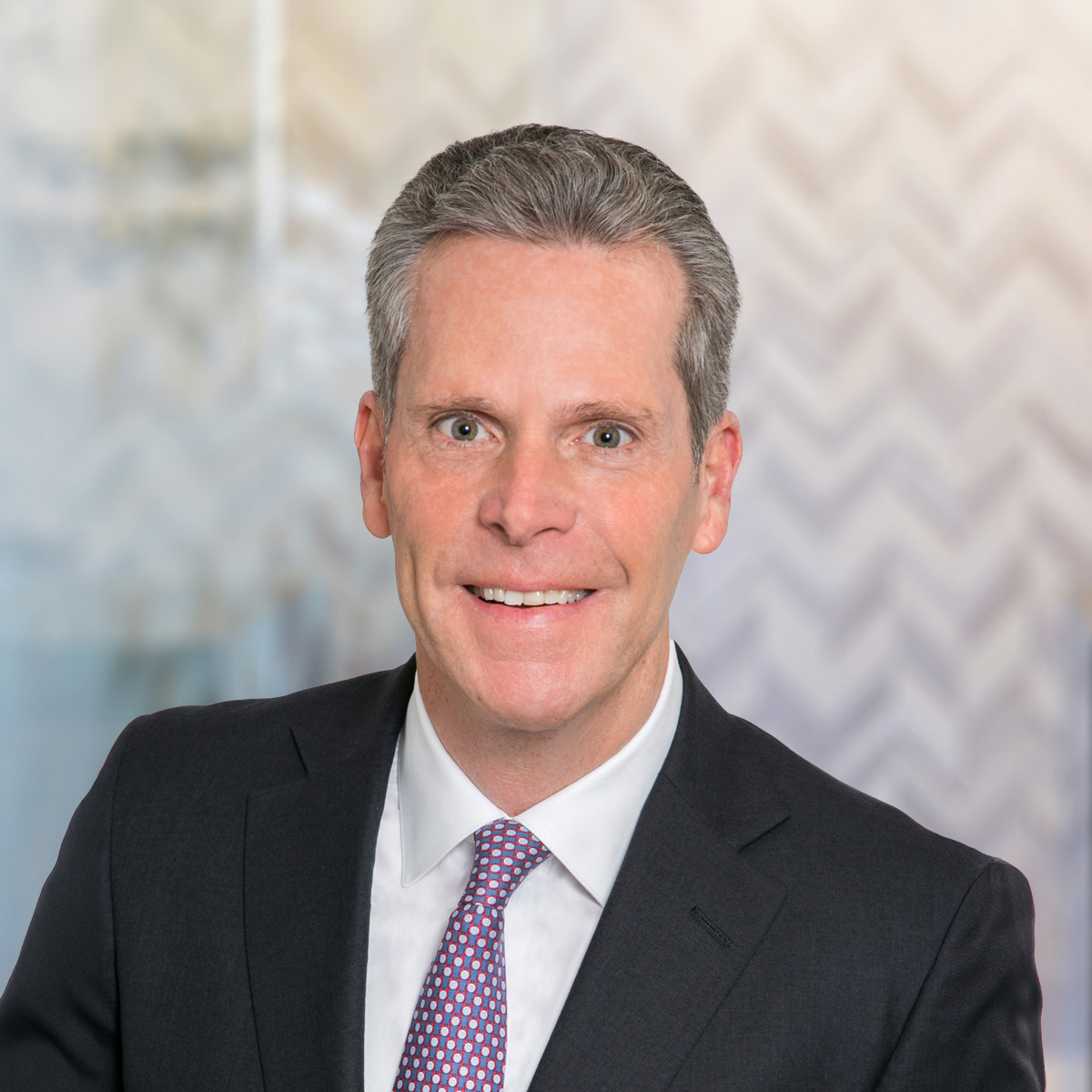 Professional headshot of Brian McDonagh with an abstract background