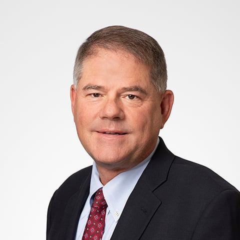 Paul Schultz professional headshot with gray background.